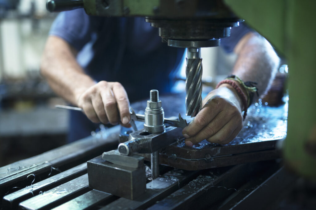 Operario trabajando en máquina industrial en taller metalmecánico